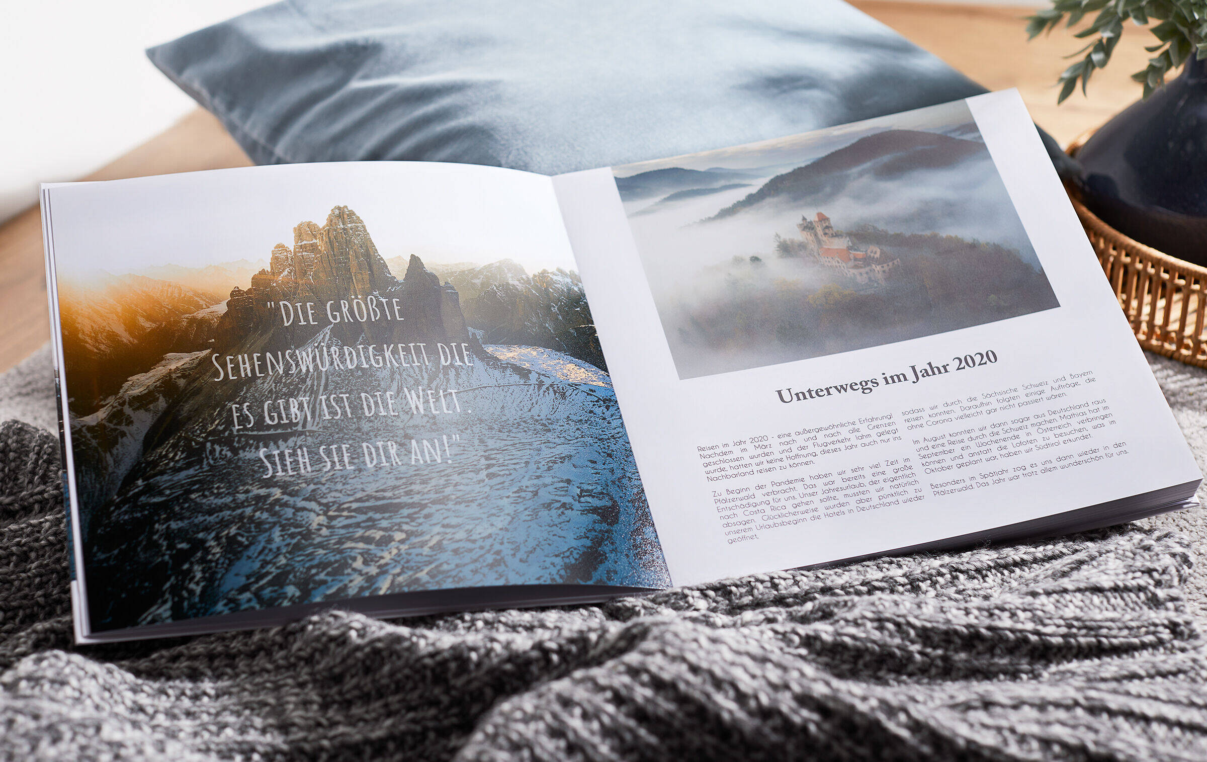 Auf der linken Seite des Fotobuchs befindet sich auf einem Foto ein Zitat über das Reisen. Das Foto scheint transparent hindurch.