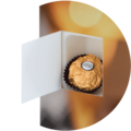 Eine goldene Praline in einer offenen Schachtel mit buntem Hintergrund