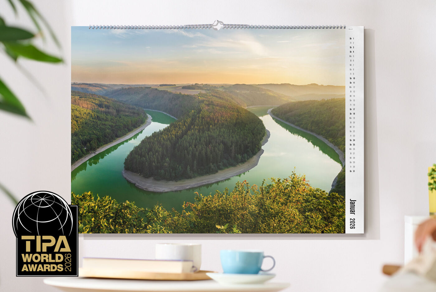CEWE Fotokalender mit Landschaftsbild hängt an einer weißen Wand