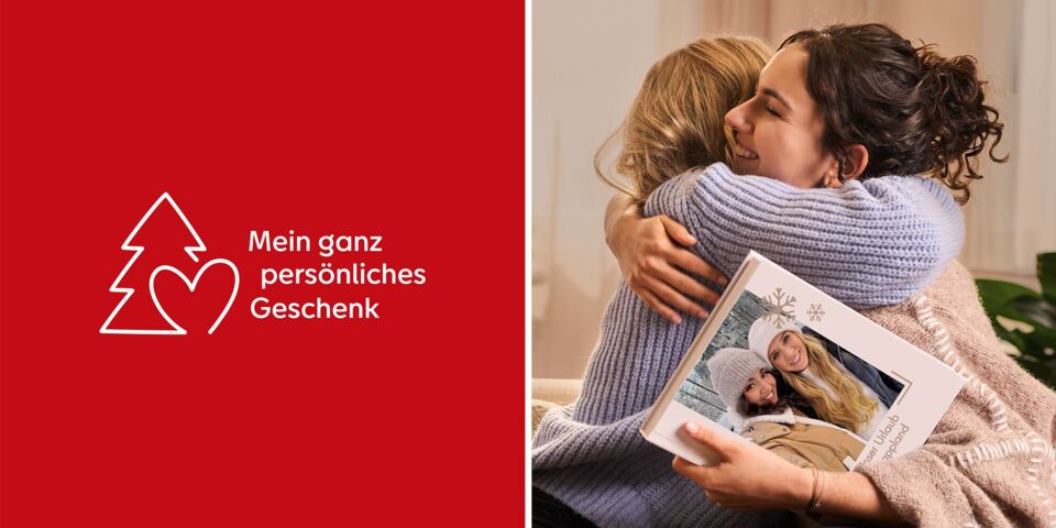 Zwei Personen umarmen sich, eine hält ein CEWE FOTOBUCH in der Hand.