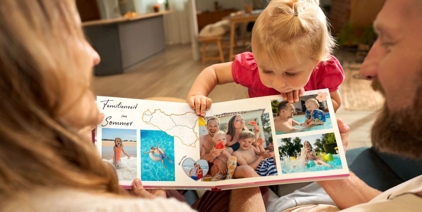 Kleines Mädchen betrachtet gemeinsam mit seinen Eltern ein aufgeschlagenes Fotoalbum mit Familienfotos.