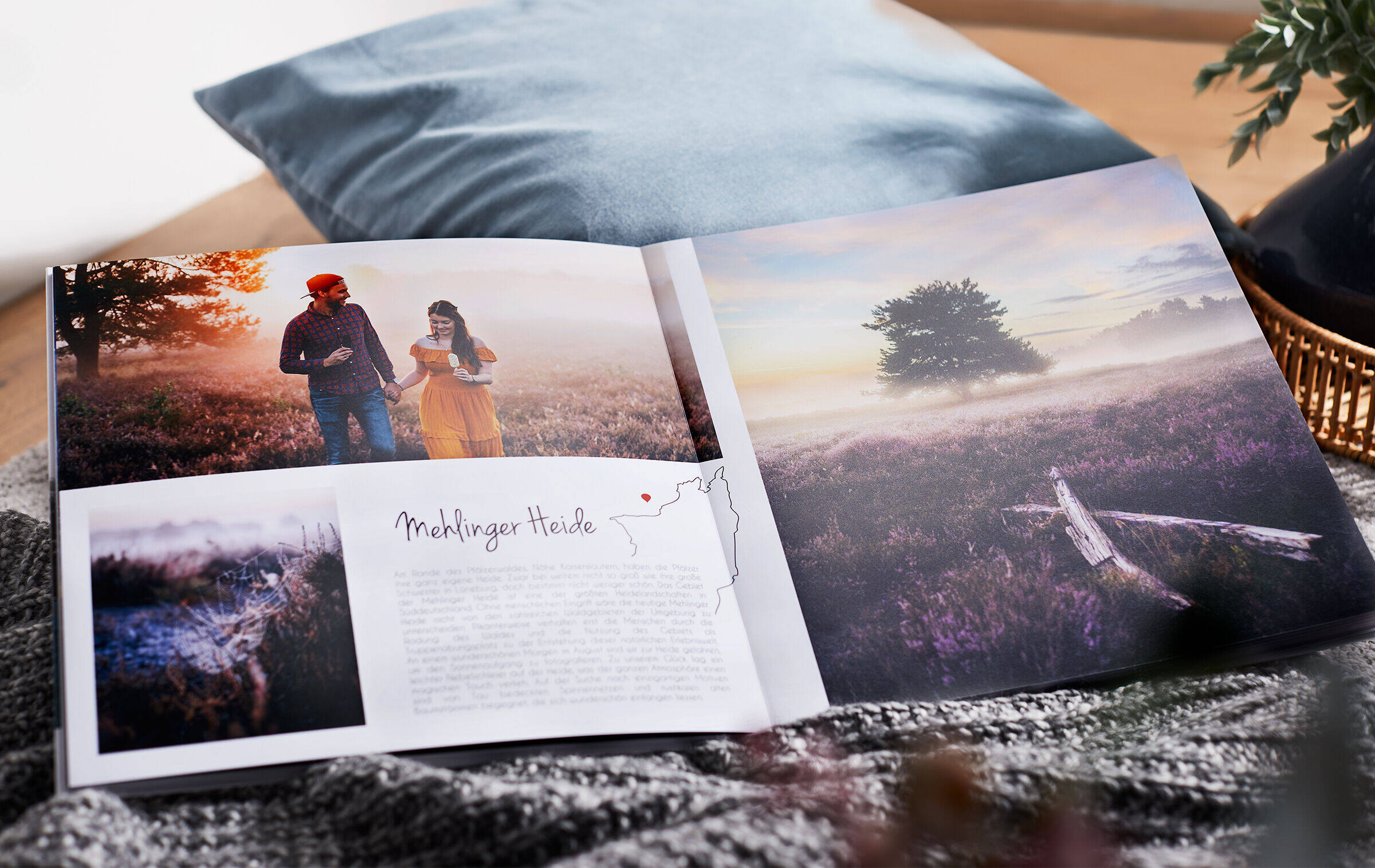 Eine Doppelseite im aufgeschlagenen CEWE FOTOBUCH zeigt Reisefotos und das Paar Annika und Mathias Koch in der Mehlinger Heide.