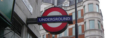 Ein typisches U-Bahn Schild mit dem Aufdruck "UNDERGROUND" an einer Hauswand Londons.